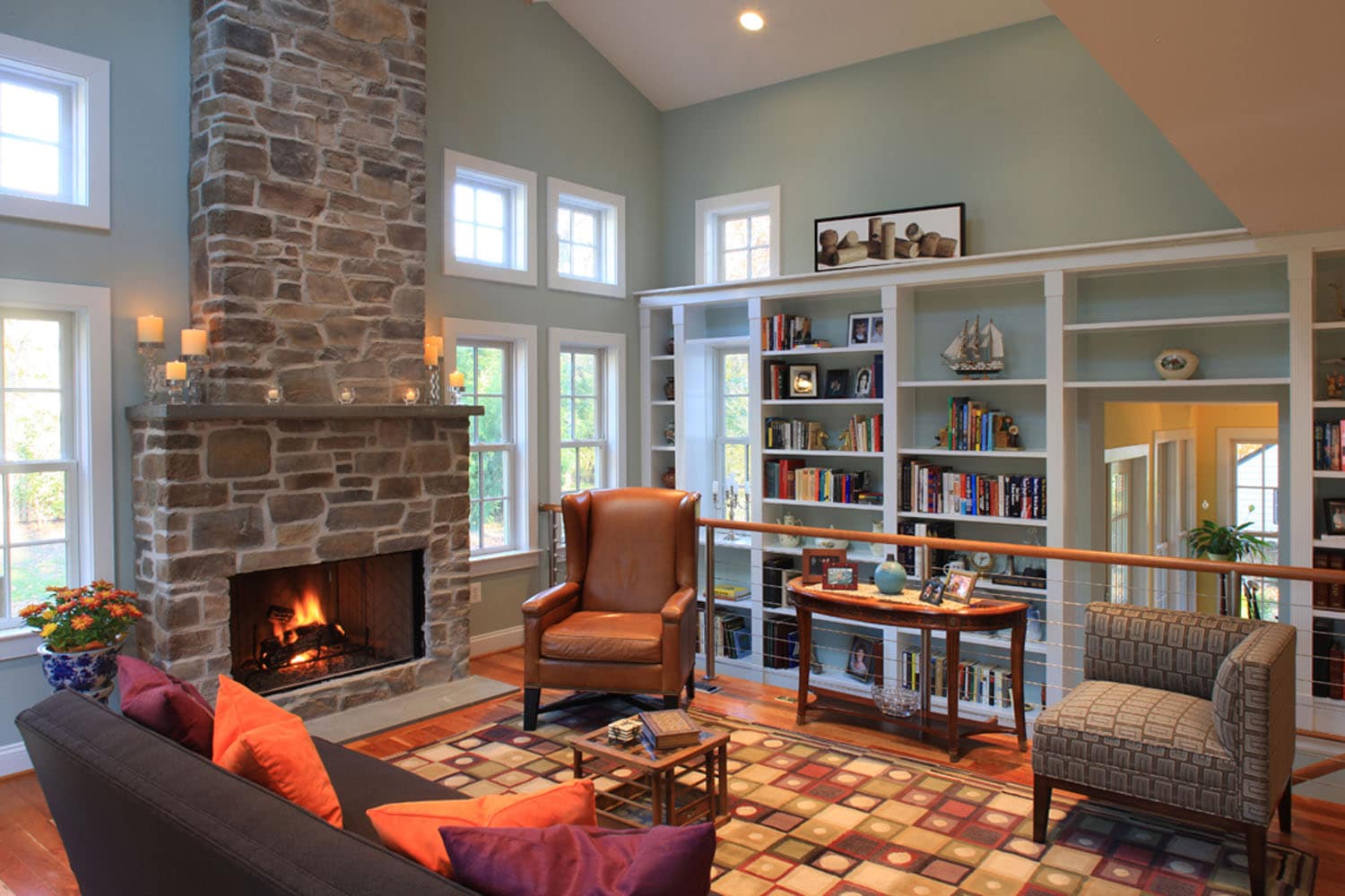 Living room with a stone fireplace and built-in shelving